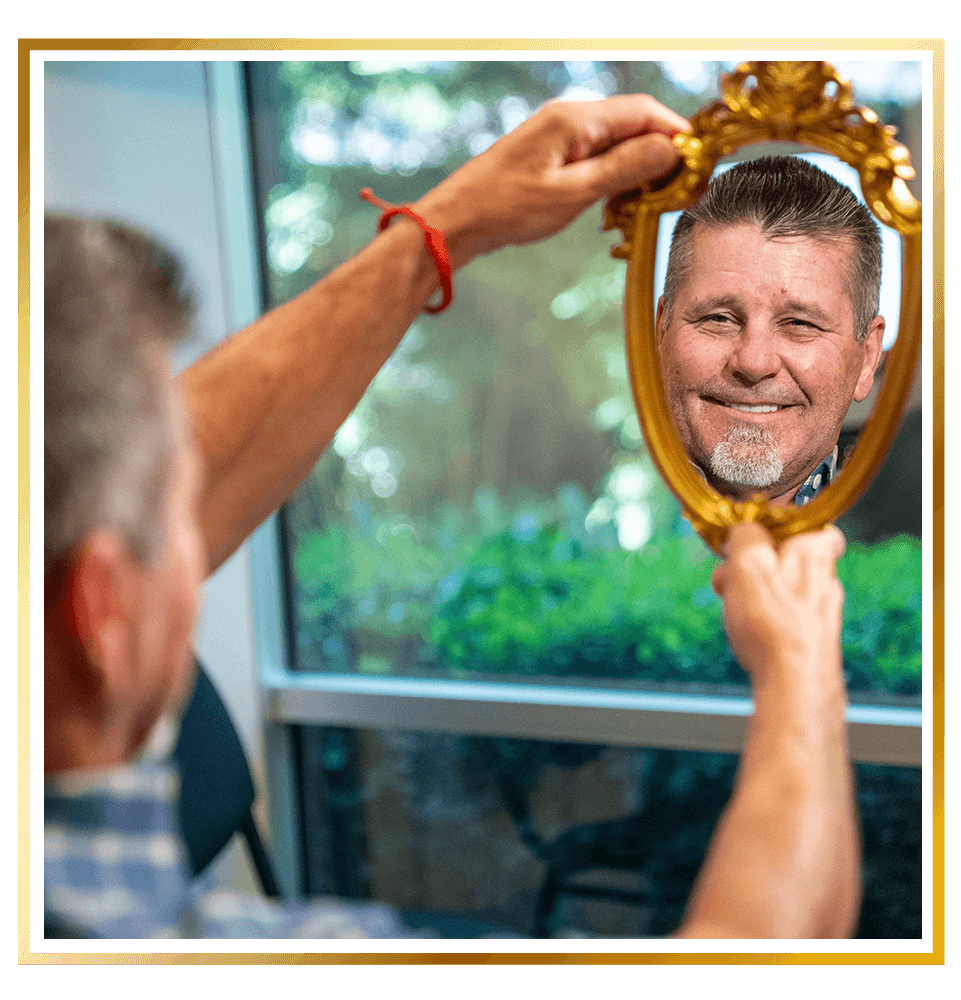 Paitent looking in mirror at their new dental implants