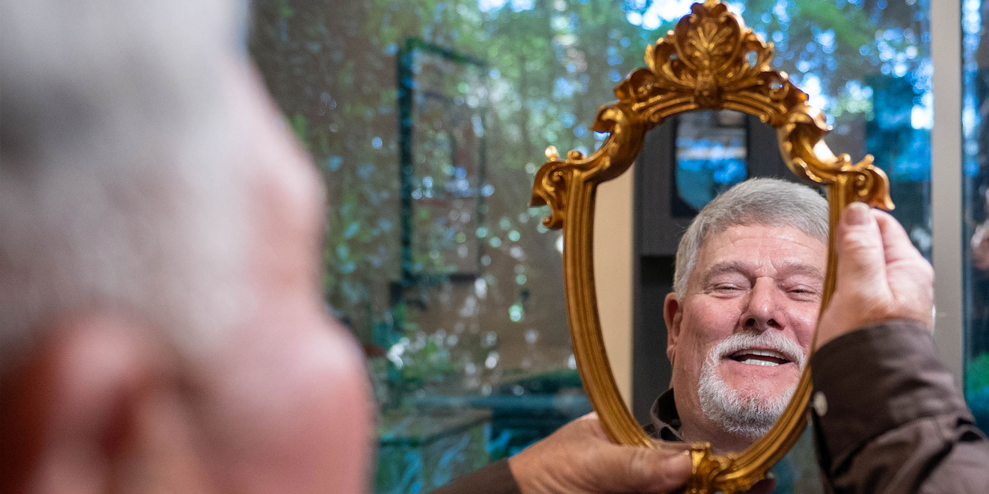 Paitent looking at newly whitened teeth in mirror