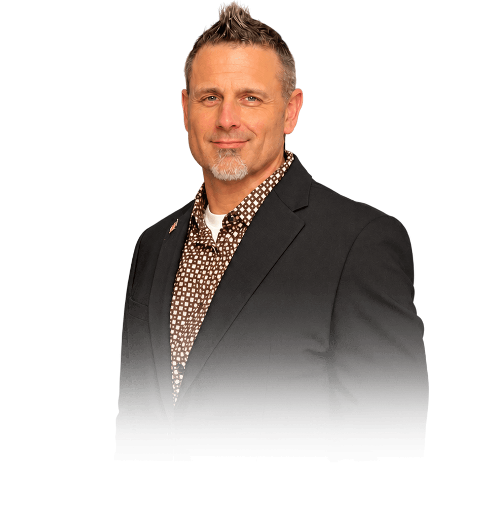 Dr. Eric J. Steinbrecher wearing a dark suit and patterned shirt.